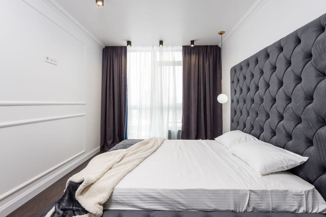 Spacious elegant bedroom with tufted headboard