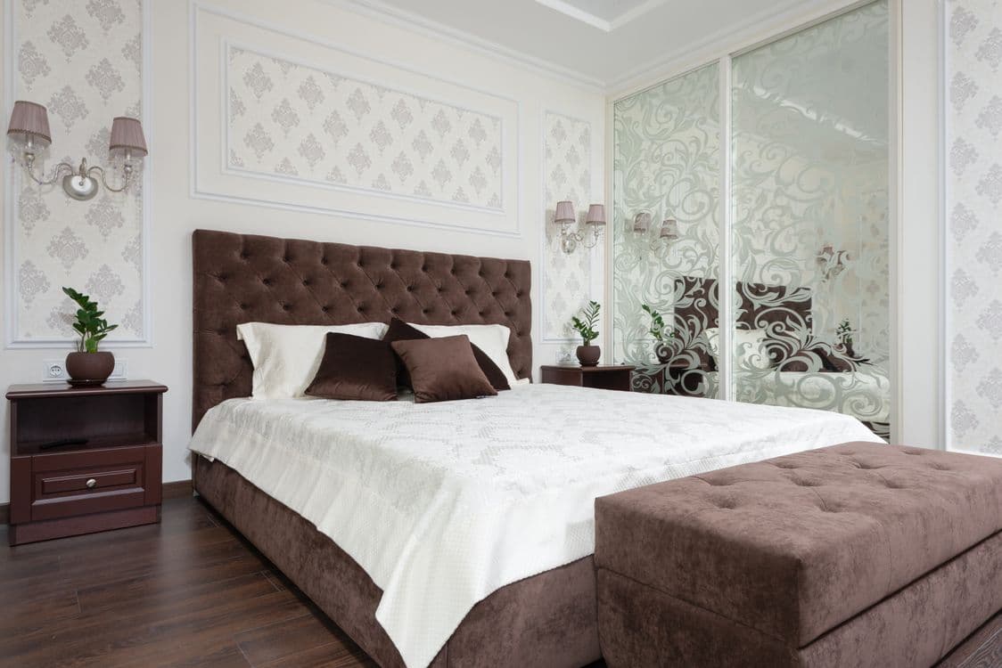 Bedroom with ornate designs and brown tufted headboard