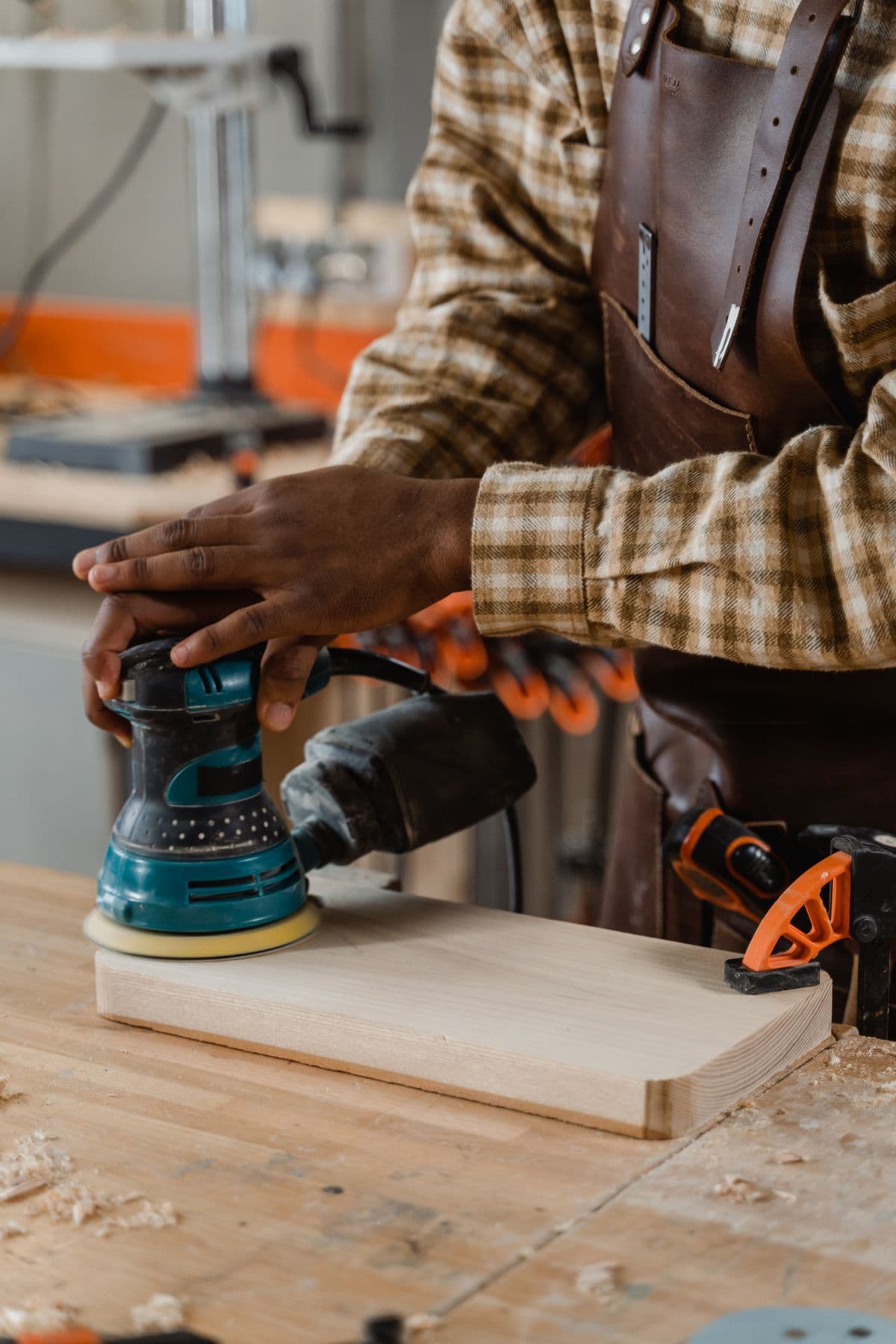 Craftsman sanding wood in workshop